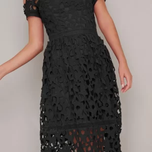 Vestido negro corto elegante con hombros descubiertos, tela de fino encaje, ceñido en la parte del dorso, falda amplia con transparencias a nivel de las rodillas. Cómo combinar un little black dress (mini vestido negro).